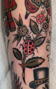 a close up of a person's leg with tattoos on it, including an owl and ladybug