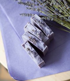 lavender soap bars sitting on top of a purple napkin next to some dried lavender flowers