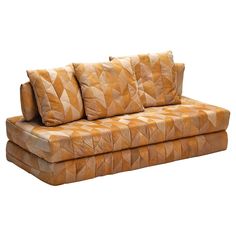 a brown couch with three pillows on it's back and one arm facing the camera