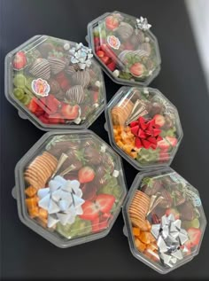 four plastic containers filled with different types of food