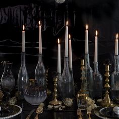 a table topped with lots of glass bottles and candles