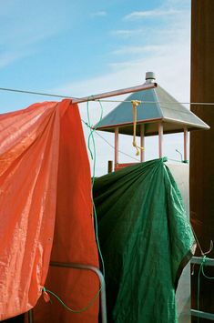 there is a green tarp on top of a building next to some orange sheets