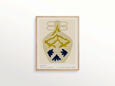 an art print with blue and yellow leaves in a wooden frame on a white wall