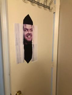 the door is open and there is a paper cut out of a man's face