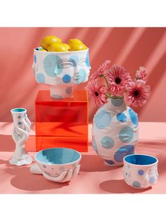 colorful vases and bowls with flowers in them