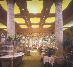 an ornately decorated lobby with columns and chandeliers on either side of the room