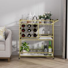 a gold bar cart with bottles and glasses on it next to a couch in a living room