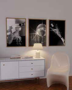 two black and white pictures hang on the wall next to a sideboard with a lamp