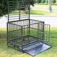 a metal cage sitting in the grass next to a tree