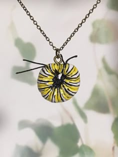 a yellow and black beaded necklace hanging from a chain