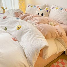 an unmade bed with many pillows on it