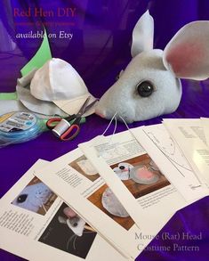 a stuffed animal mouse sitting on top of a table next to some papers and scissors