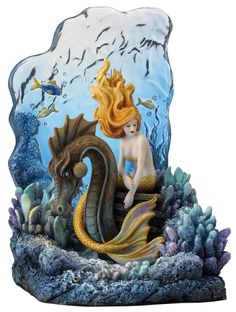 a statue of a mermaid sitting on top of a sea horse