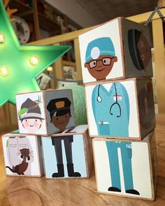 wooden blocks with doctors on them and a green star in the background, sitting on a table