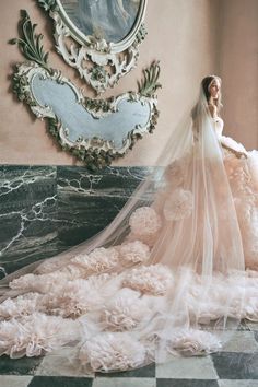 a woman in a wedding dress standing on a checkered floor with her veil pulled back