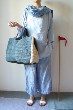 a woman is holding a crocheted bag