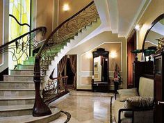 an elegant foyer with marble flooring and handrailed staircase leading up to the second floor