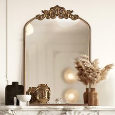 a mirror sitting on top of a white mantle