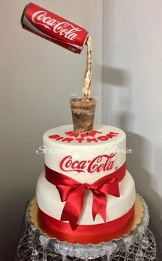 a coca cola cake with a coke can being poured into the top and on top