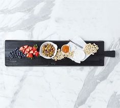 a black tray topped with fruit and cereal