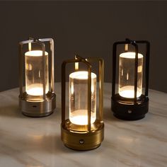 three lit candles sitting on top of a table next to a vase with flowers in it