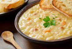 a bowl of soup with bread and parsley on the side