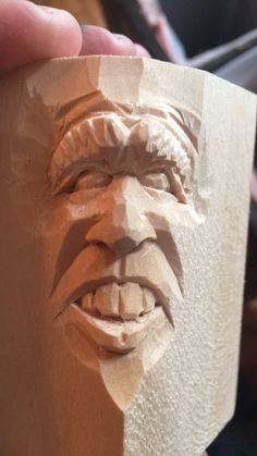 a person holding a clay sculpture of a man's face