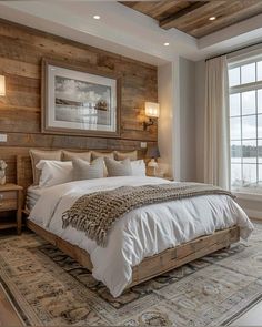 a large bed sitting next to a window in a bedroom under a wooden headboard