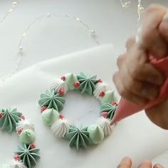 someone is decorating a christmas wreath with icing