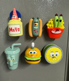 the magnets on the refrigerator are decorated like cartoon characters