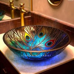 a bowl shaped sink with peacock feathers on it