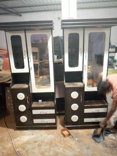 a man is working on two black and white dressers