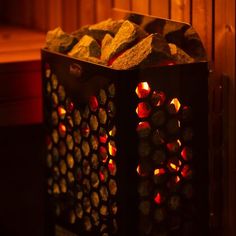 a black box with red and yellow lights in it sitting next to a wooden wall