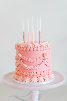 a pink cake sitting on top of a white plate