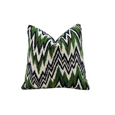 a green and white pillow on a white background