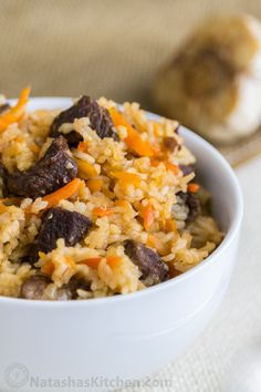 a white bowl filled with rice and meat