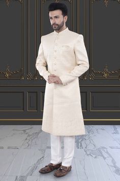 This men's sherwani (traditional Indian attire) features expertly crafted thread and sequin work. The intricate detailing adds a touch of elegance to any occasion. Made from high-quality materials, it offers both style and comfort. Perfect for those seeking a traditional yet sophisticated look. Elegant Cream Bandhgala With Chikankari Embroidery, Formal Cream Nehru Jacket With Chikankari Embroidery, Elegant Embroidered Sherwani For Eid, Ceremonial Long Cream Sherwani, Elegant Traditional Style Kurta, Elegant Sherwani With Chikankari Embroidery For Diwali, Fitted Long Sherwani With Chikankari Embroidery, Cream Chikankari Embroidered Sherwani For Formal Occasions, Elegant Cream Nehru Jacket With Chikankari Embroidery