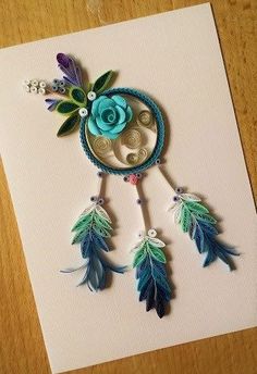 a card with an image of a dream catcher and flowers on the front, sitting on a table