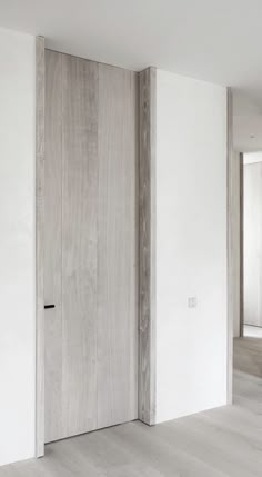 an empty room with white walls and wooden doors