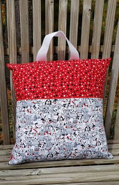 a red and white bag sitting on top of a wooden bench