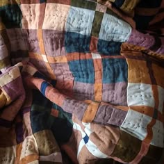 a quilted blanket with multi colored squares on it