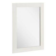 a white bathroom mirror sitting on top of a wall