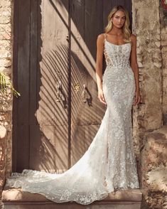 a woman standing in front of a door wearing a wedding dress