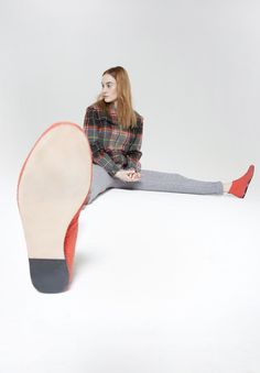 a woman is sitting on the floor with her feet up and wearing grey tights