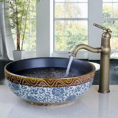 a bowl shaped sink with a faucet running water