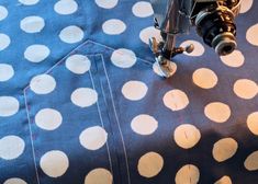 the sewing machine is working on the polka dot fabric