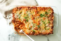 a casserole dish with meat and cheese in it on a marble counter top