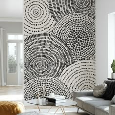 a living room with a couch, coffee table and wallpaper in black and white