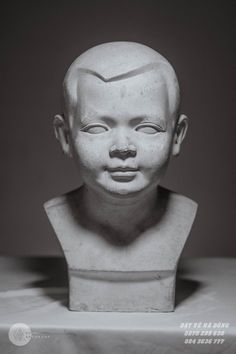 a black and white photo of a statue of a man's head with his eyes closed