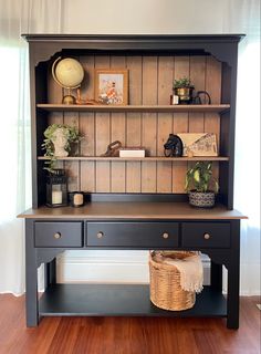 a black desk with shelves and baskets on it